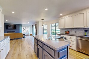 Enjoy cooking in this well-lit kitchen with a sink, ample counter space, and stainless steel appliances.