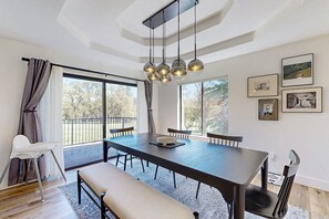 Enjoy meals with family and friends in this stylish dining area, featuring a large table and comfortable seating for four.