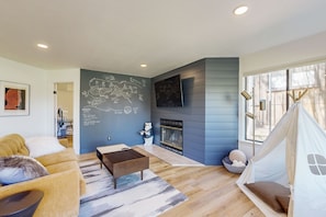 Relax in this stylish living room with a large flat-screen TV, plush sofa, and a unique corner feature.