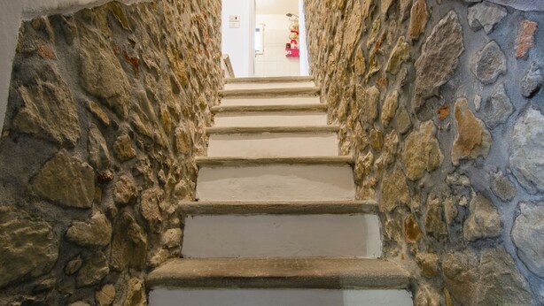 A stone staircase leading to a room with a white door.