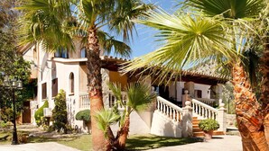 A Mediterranean-style villa with a pool, palm trees, and a stone staircase leading to a covered area. - Beautifully Restored Country House, A/C Private Pool, Mountain Views - 10mins to Old Town Pollenca (Pollença)