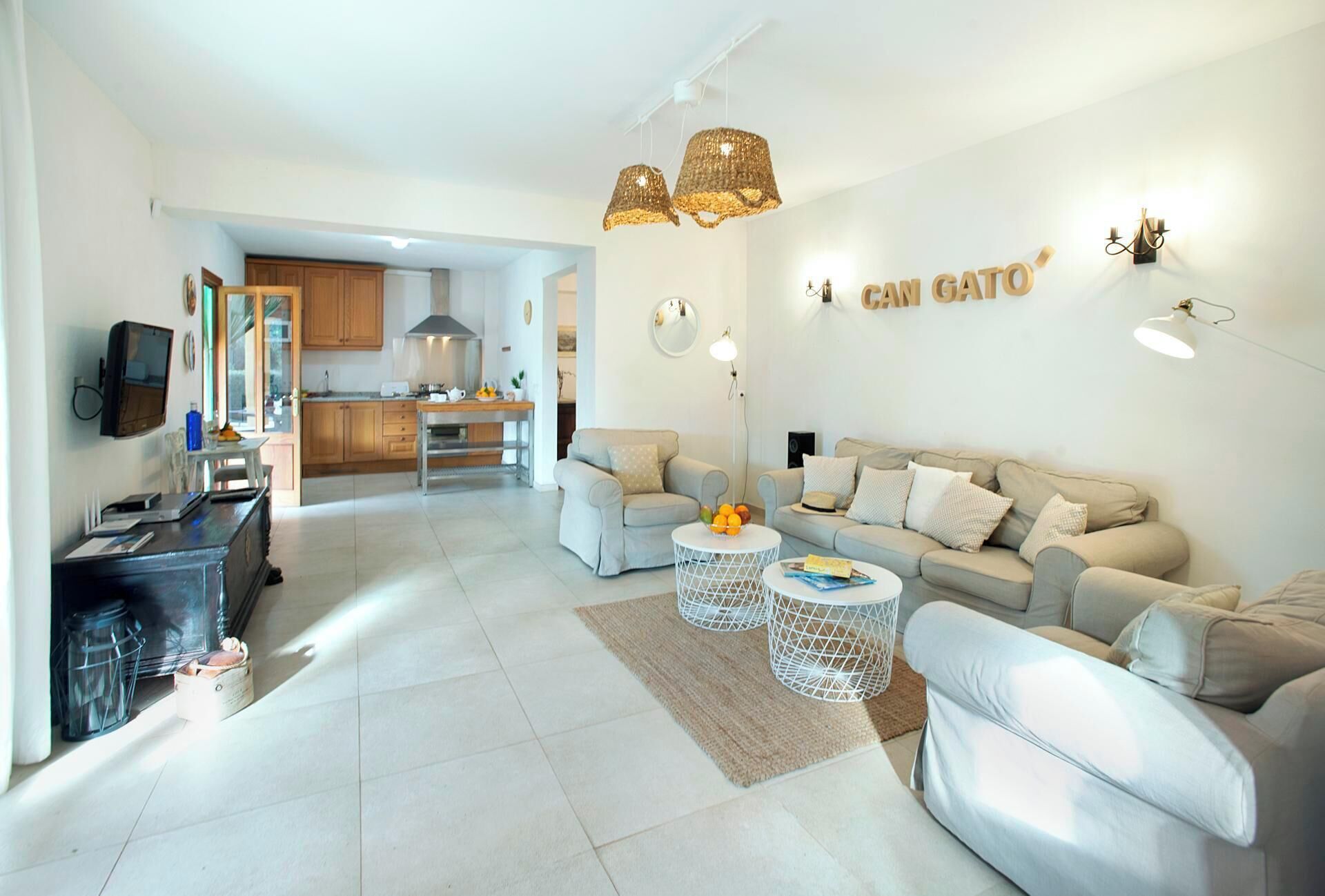 A modern living room with a sofa set, a coffee table, and a kitchen in the background.