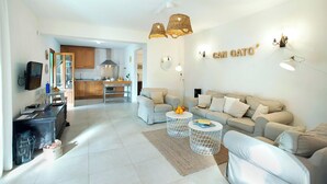 Un saló modern amb un sofà, una taula de centre i una cuina al fons.