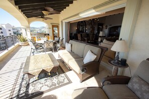 A sunlit outdoor seating area with a sofa, chairs, and a table, overlooking a scenic view. - Las Mananitas, San Jose del Cabo, Beachfront Penthouse, Oceanview from all rooms (San Jose del Cabo)