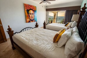 Ein Hotelzimmer mit zwei Betten, einem Bild an der Wand und einem Balkon mit Blick.