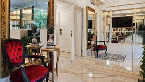 En lyxig lobby med en storslagen spegel, elegant möblemang och en modern kristallkrona.