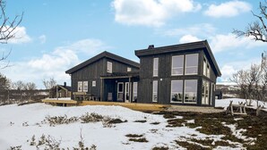 A modern two-story house with a wooden exterior, a covered patio, and a snow-covered landscape. - Cozy home in ålen with WiFi (Ålen)