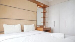 Ein Hotelzimmer mit einem großen Bett, einem Holz-Kopfteil, einem Spiegel und einem Kleiderschrank.