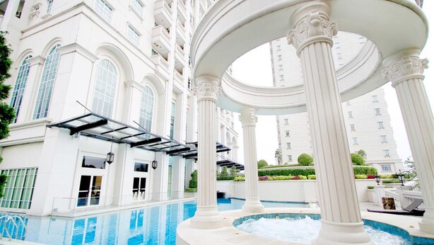 Ein luxuriöses Hotel mit großem Hallenbad, klassischer Architektur und einem gepflegten Garten.