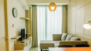 Ein modernes Wohnzimmer mit einer Couch, einem Fernseher, einem Holztisch und einem Esstisch.