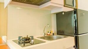 Eine moderne Küche mit einer Edelstahlspüle, einer eingebauten Mikrowelle und einem Kühlschrank.