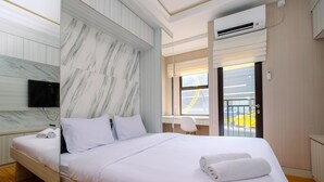Ein modernes Hotelzimmer mit einem großen Bett, einem an der Wand montierten Fernseher und einer Klimaanlage.