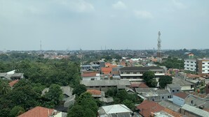 A densely packed urban area with various buildings, including residential and commercial structures. - Compact Studio At Margonda Residence 1 Apartment (Depok)