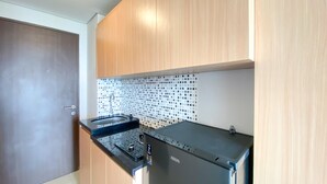 Una cocina con armarios de madera, encimera negra y salpicadero de azulejos.