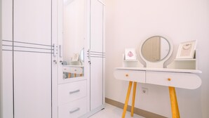 A modern bathroom with a white vanity, a mirror, and a framed picture. - Comfort And Nice 2Br At Tokyo Riverside Pik 2 Apartment (Teluknaga)