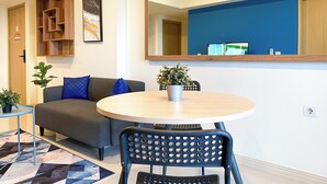 Una sala moderna con un sofá, una mesa de comedor redonda y un espejo grande.