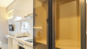 Eine moderne Küche mit eingebautem Geschirrspüler, Spüle und einer Arbeitsplatte mit Kaffeemaschine.