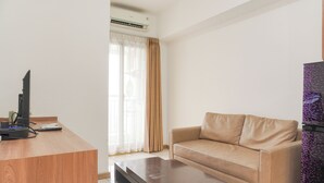 A modern living room with a wooden desk, a beige sofa, and a coffee table.
