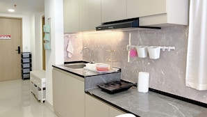 Una cocina moderna con encimera de mármol, horno empotrado y pileta de acero inoxidable.