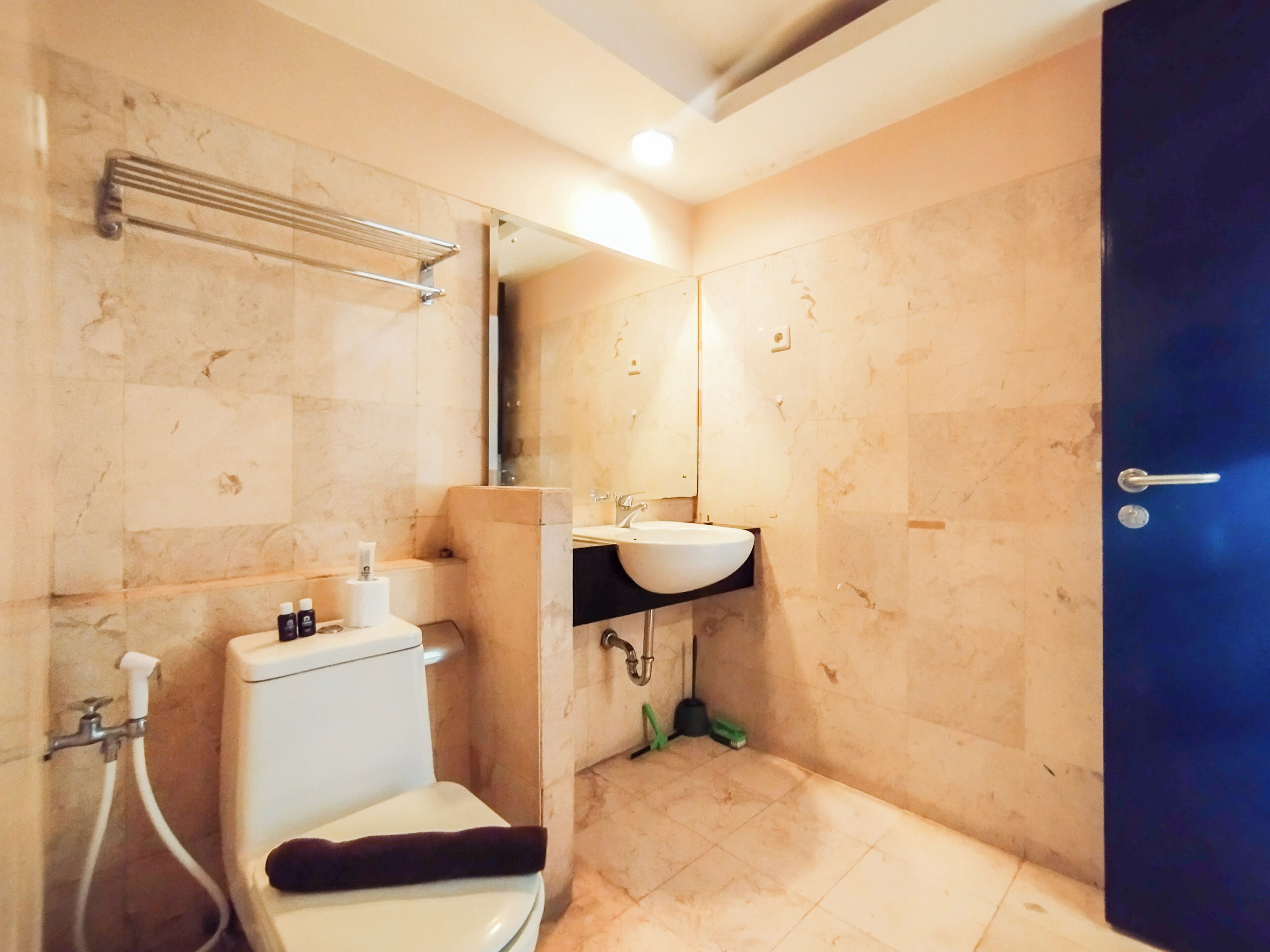 Et badeværelse med toilet, vask og brusebad.