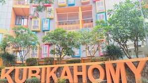A building with colorful window frames and a sign that reads "KURIKAHOMY". - Good Deal Studio Loft Mezzanine (No Kitchen) At Kubikahomy Apartment (Pagedangan)