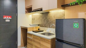 Eine moderne Küche mit Edelstahlkühlschrank, Holzschränken, einer Spüle und einer Arbeitsplatte mit einer Waage.