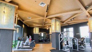 Ein Fitnessstudio mit Laufbändern, Crosstrainern und Gewichten.