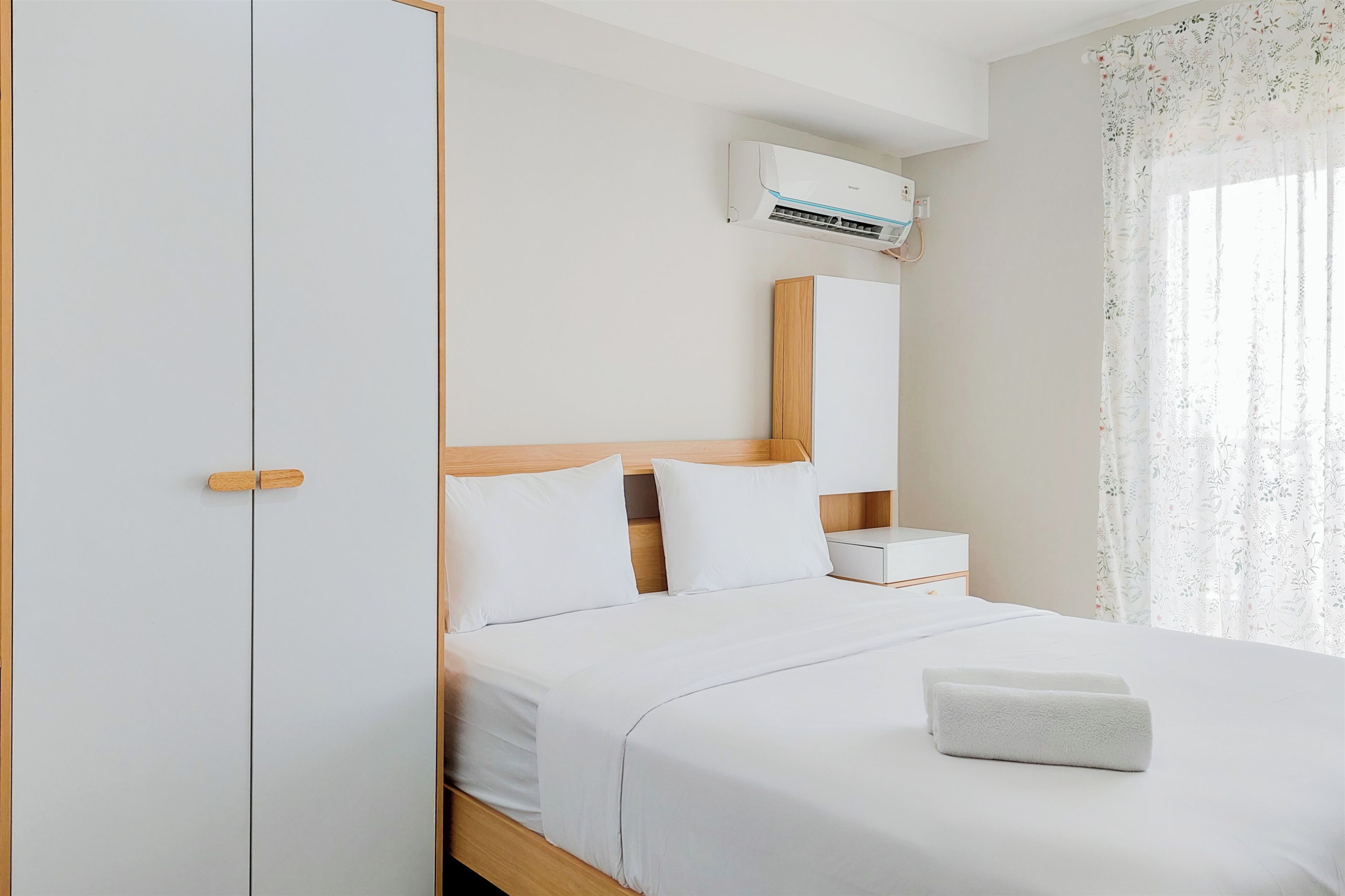 Une chambre d’hôtel équipée d’un lit, d’une table de chevet, d’un miroir et d’un appareil de climatisation.