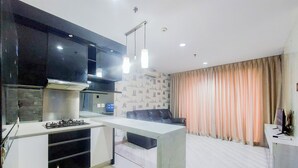 A modern kitchen with a built-in stove, black cabinets, and pendant lights.