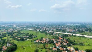 An aerial view of a town with a prominent highway, green fields, and scattered houses. - Furnished And Cozy Studio Sky House Alam Sutera Apartment (Tangerang)