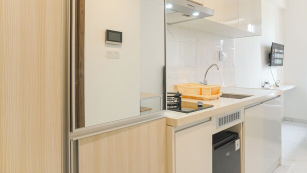 A modern kitchen with a built-in oven, a sink, and a dishwasher. - Furnished And Cozy Studio Sky House Alam Sutera Apartment (Tangerang)