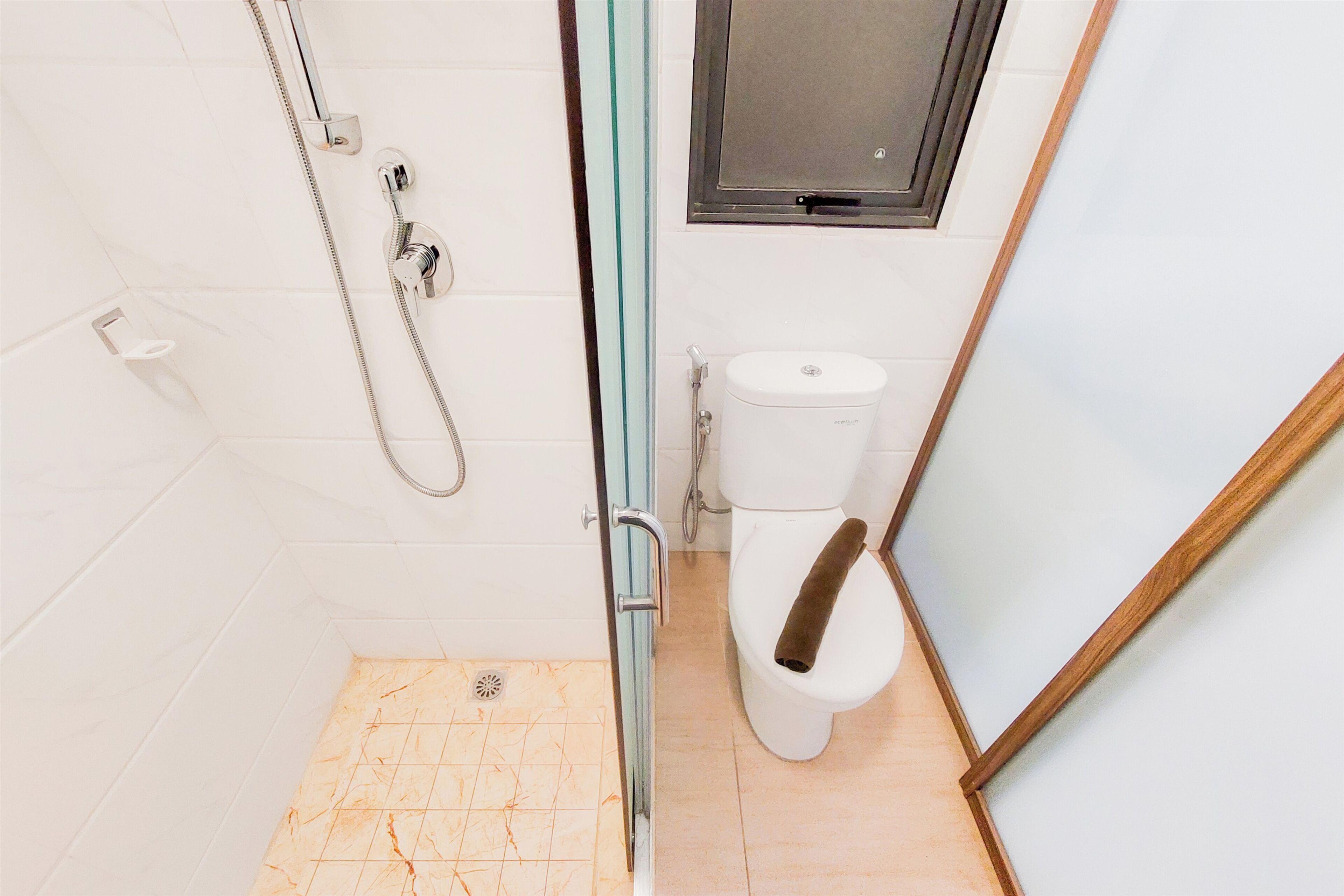 Ein Badezimmer mit Dusche, Toilette und Glastür.