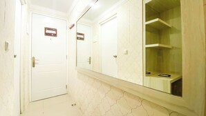 A bathroom with two white doors, a large mirror, and a tiled wall. - Cozy And Minimalist Studio Paltrow City Apartment (Semarang)