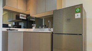 Een moderne keuken met een roestvrijstalen koelkast, een ingebouwde oven en een wit aanrecht.