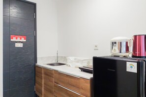 Studio | Privékeuken | Een koelkast met diepvriezer, een kookplaat, een waterkoker