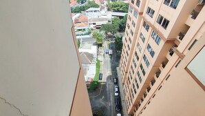 Un immeuble de grande hauteur doté de nombreux balcons et offrant une vue sur une rue en contrebas.