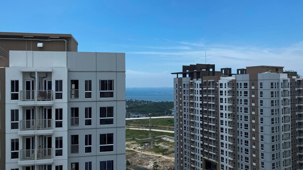 Un edificio alto con varios balcones y vista al mar.