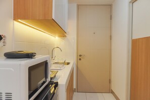 Studio | Private kitchen | Full-size fridge, microwave, stovetop, electric kettle - Good Choice And Simply Studio Tokyo Riverside Pik 2 Apartment (Teluknaga)