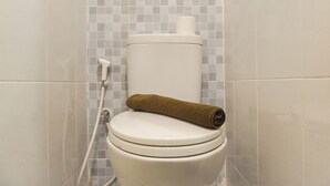 Toilette mit Toilettenpapier und Handtuch.