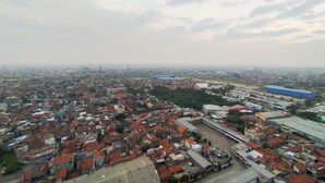 An aerial view of a densely populated urban area with numerous buildings and a large open space in the center. - Modern 2Br At Mekarwangi Square Cibaduyut Apartment (Bandung)