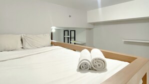 A hotel room with a bed, a mirror, and a ceiling light. - Restful And Well Designed Studio Transpark Juanda Bekasi Timur Apartment (Bekasi)