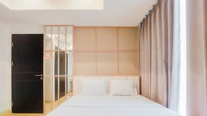 A bedroom with a bed, a wardrobe, and a mirror. - Modern Look And Cozy 1Br Branz Bsd City Apartment (Pagedangan)