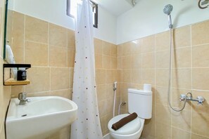 Ein Badezimmer mit Waschbecken, Toilette, Dusche und einem Fenster mit Vorhang.