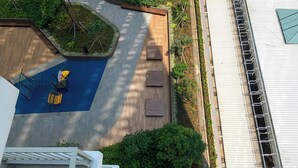 A rooftop terrace with a pool, seating area, and a view of the building's exterior. - Compact Studio At Tokyo Riverside Apartment (Teluknaga)