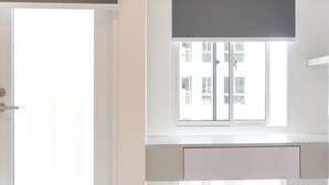 A modern room with a large window, a desk, and a door. - Compact Studio At Tokyo Riverside Apartment (Teluknaga)