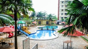 A pool area with a slide, seating, and a sign. - Cozy Living Studio At Kebagusan City Apartment (Jakarta)