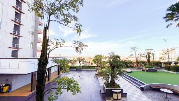 Un espace extérieur moderne avec un sol à carreaux, des jardinières et une zone herbeuse.