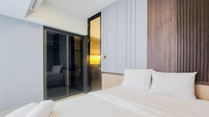 Une chambre d’hôtel avec un lit, une grande fenêtre et une porte coulissante donnant sur un balcon.