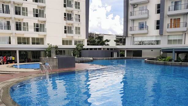 A modern residential building with a swimming pool. - Well Furnished And Cozy Studio Casa De Parco Apartment (Pagedangan)