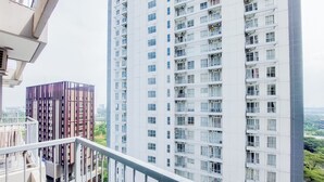 A high-rise building with multiple floors, balconies, and a view of a cityscape. - Well Furnished And Cozy Studio Casa De Parco Apartment (Pagedangan)